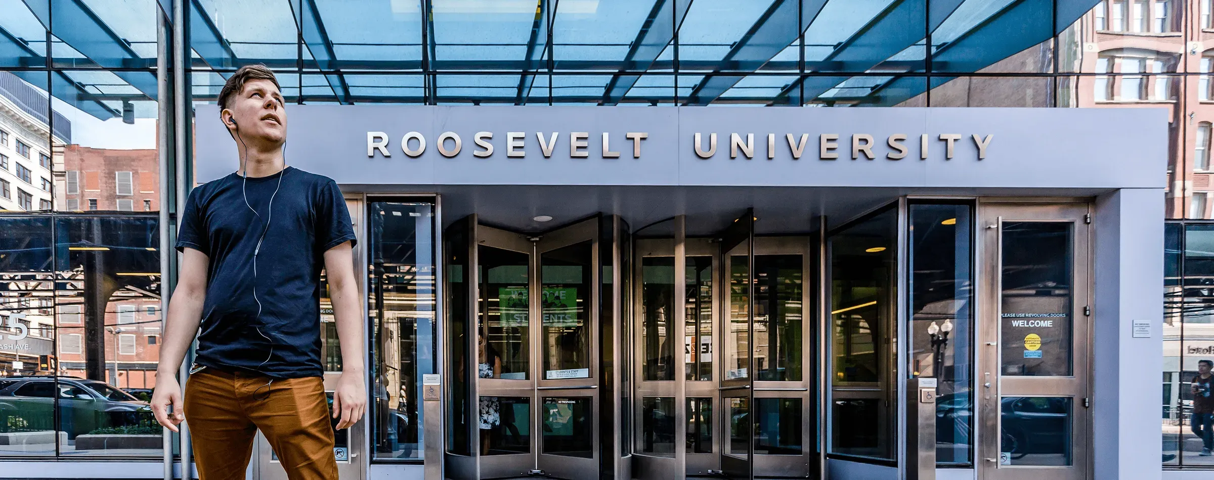 Entrance of Roosevelt University with red signage and stone facade.
