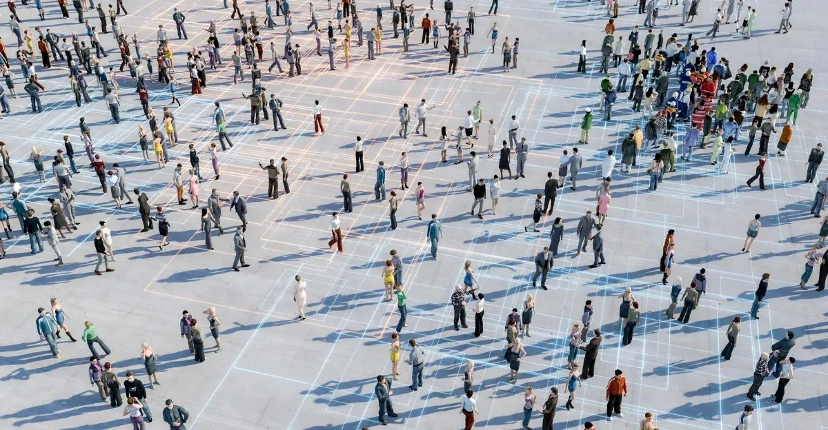 Aerial view of a crowd scattered across a gridded plaza, with a dense group gathered in one corner