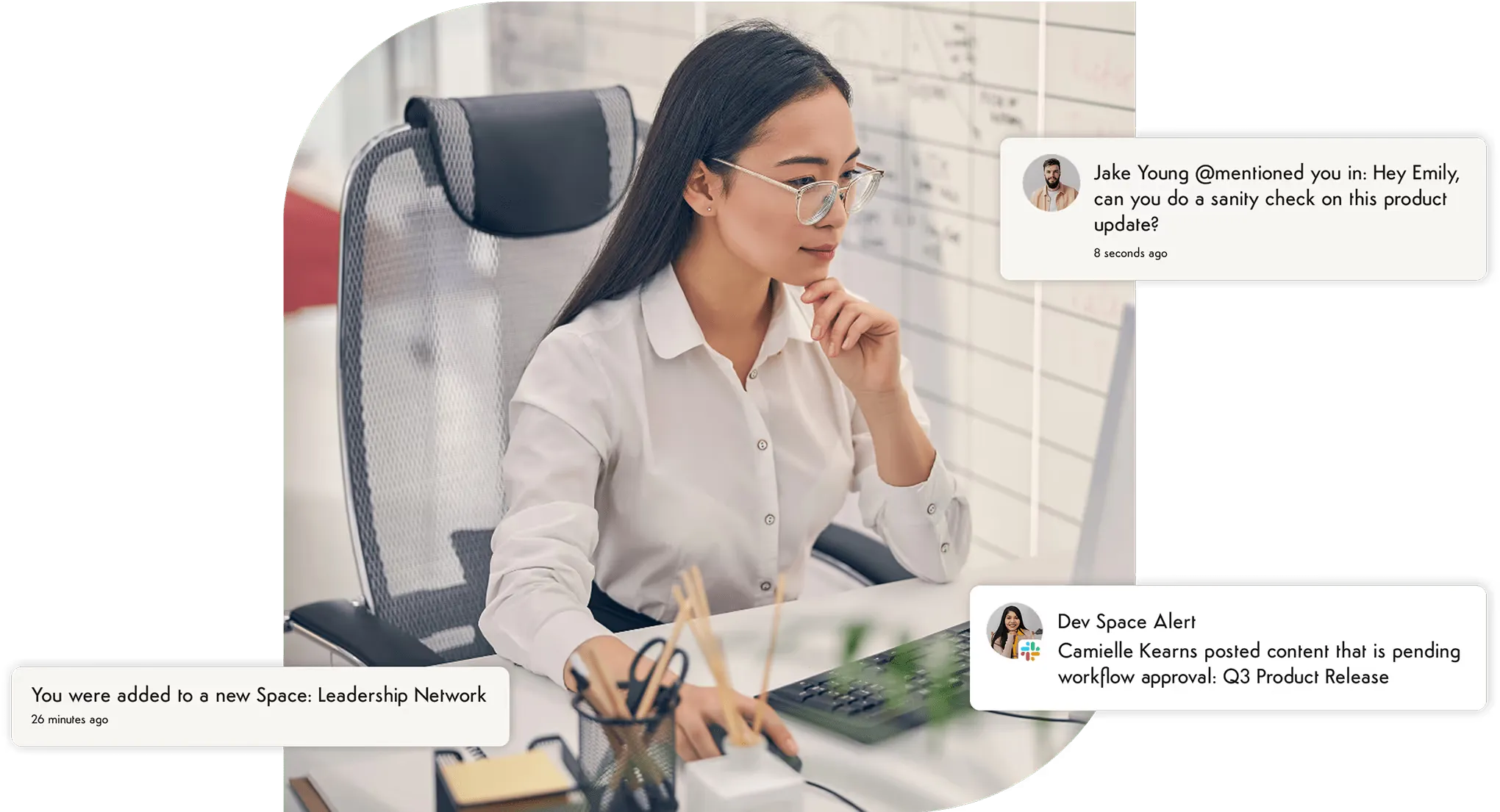Focused woman at computer with pop-up notifications for mentions, space additions, and approvals.