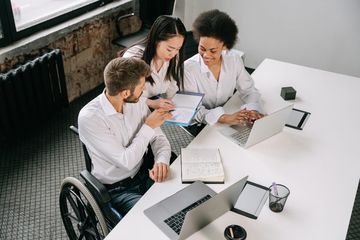 A collaborative team meeting reviewing an employee handbook to update company policies and integrate employee feedback for better organizational alignment.