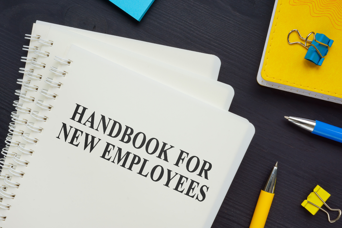 A professional employee handbook resting on an office desk, representing a central resource for company policies, employment guidelines, and organization standards.